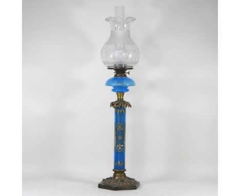 An ornate 19th century brass oil lamp, the blue opaque glass column finely painted with arabesques, with an opaline glass fon