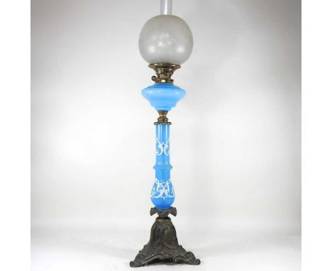 A large 19th century brass oil lamp, with a painted blue glass column and opaline font, on an ornate scrolled base, with an e