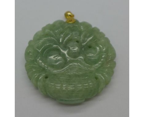 A carved jade pendant with 14ct gold mount