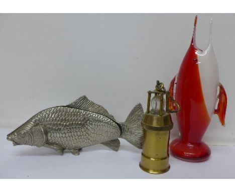 A Murano glass fish vase, a miniature brass lamp and a salmon serviette holder