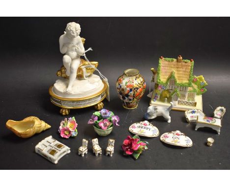 A cherub sitting on a conch shell; Masters House, Walport, decanter labels; eight miniature dolls house pieces; etc