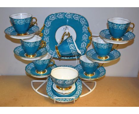 A Windsor tea service for six decorated with ripe fruits and vine leaves on a turquoise ground, comprising bread and butter p
