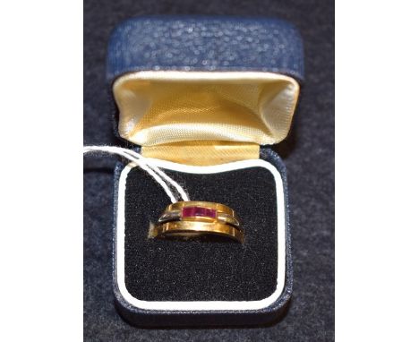 An 18ct gold ring, channel set with three square cut ruby stones, 4.2g