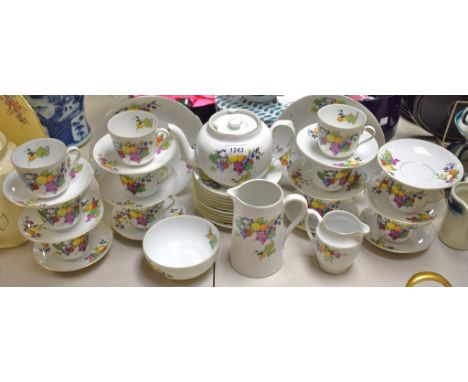 A Czechoslavakian tea service decorated with branches of ripe fruit, comprising tea pot, bread plates, side plates, jugs, cup