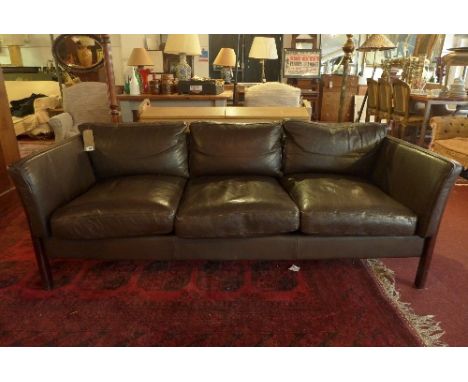 A 20th Century brown leather three seater sofa having oak frame