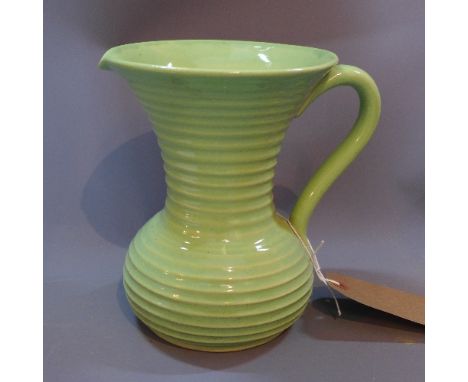 A green glazed ceramic jug, with rippled decoration, H. 19cm