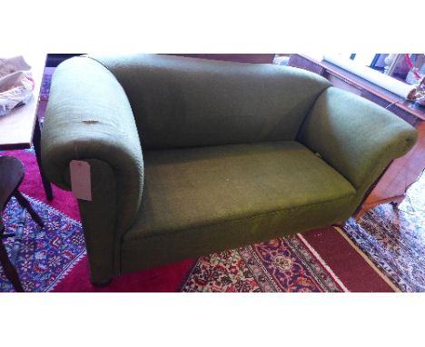 An early 20th Century drop end club sofa with green linen upholstery, raised on bun feet and castors. 