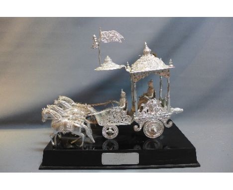 A 1940's white metal model of Shri Krishna Arjuna's chariot, raised on ebonised stand with inscription plaque, H:60cm W:70cm 