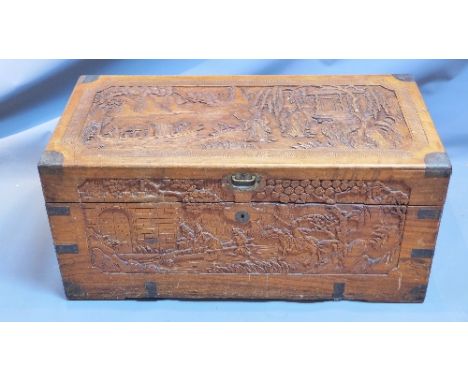 A Chinese camphor wood trunk, carved with figures, houses and foliage, H. 39cm W. 84cm D. 41cm
