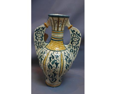 A large twin handled ceramic vase, decorated with foliage and chequered design, H. 53cm