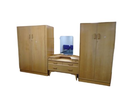 A four piece mid century G-Plan E Gomme light oak bedroom suite comprising of two double door wardrobes, dressing table and s