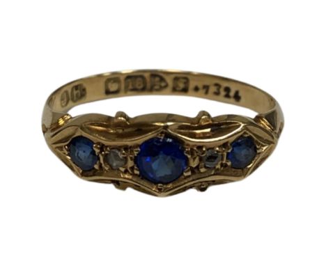 An 18ct yellow gold ring set with three synthetic sapphires, size M, 2.1g.