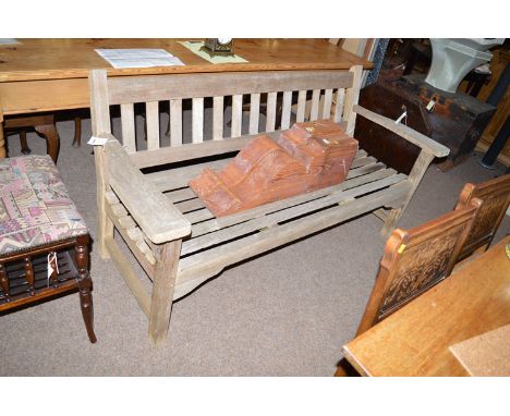 An early 20th Century teak garden bench seat with slatted base, back and shaped arms.