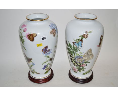 Two Franklin porcelain vases; a 'Caribbean' butterfly vase; and a 'Meadowland' butterfly vase, by John Wilkinson, on wood pli