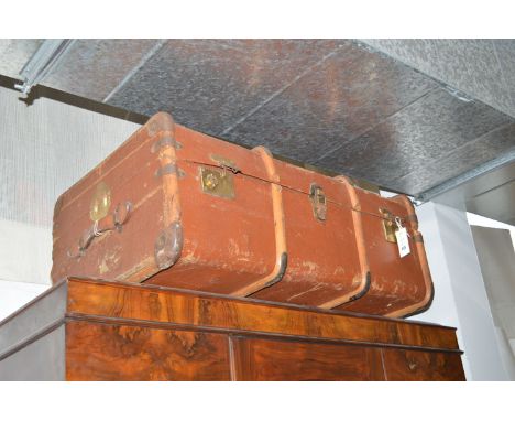 Two old trunks, one in canvas with wooden bindings, the other blue trunk with metal bindings and clasps.
