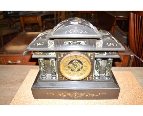 A Victorian mantel clock in architectural style polished black slate case, with decorative moulded highlights and turned marb