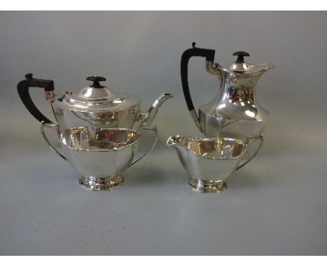 A FOUR PIECE SILVER TEA SERVICE, shaped oval form with angled rims and bases, teapot and hot water with ebonised handles and 