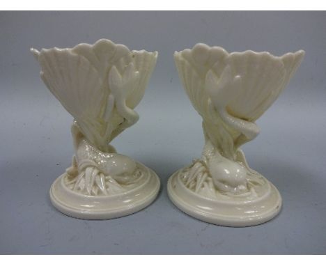 A PAIR OF ROYAL WORCESTER TABLE SALTS, in the form of shell being supported by fish on circular base, impressed mark to base 