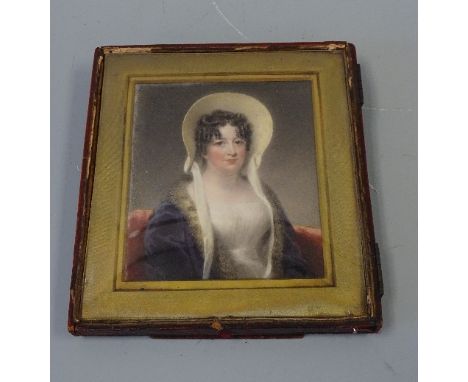 A PORTRAIT MINIATURE, depicting seated lady in bonnet on a red chair, approximately 10cm x 8.5cm in rectangular easel frame w