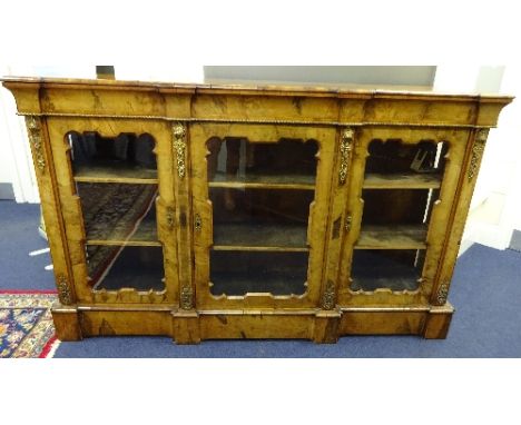 A VICTORIAN WALNUT BREAKFAST CREDENZA, with three glazed string inlaid doors to three shelf interior, on plinth base, ormolu 