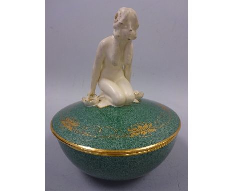A ROYAL WORCESTER ART DECO BOWL AND COVER, in green enamels with gilt rims and lotus flower decoration and figural kneeling n