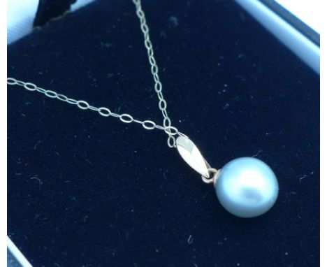 A yellow metal and pearl pendant marked K18 on a 9ct gold chain, 1.5g
