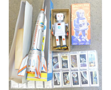 A tin-plate rocket, boxed, a clockwork robot and a set of The Race into Space tea cards