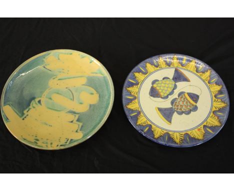 Two large glazed ceramic platters, one decorated with two fish and one with a blue and yellow abstract design. Dia.42cm. (lar