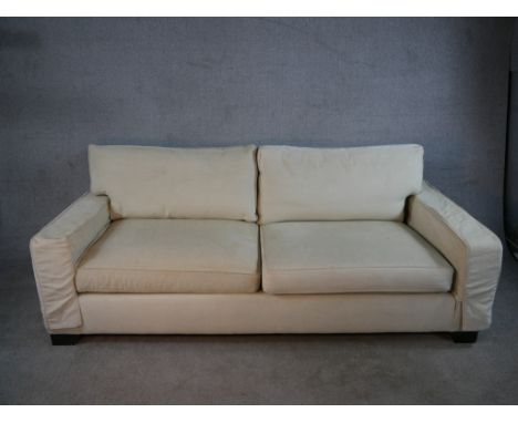 A contemporary Kingcome two seater cream upholstered sofa raised on block feet. H.84 W.220 D.100cm.