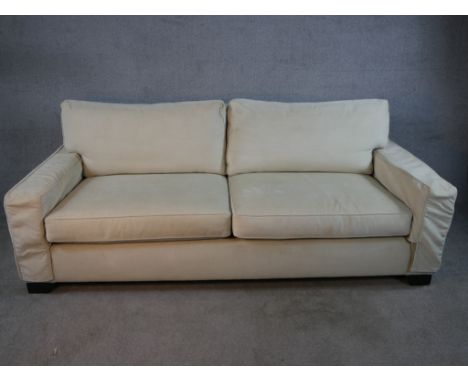 A contemporary Kingcome two seater cream upholstered sofa raised on block feet. H.84 W.220 D.100cm.
