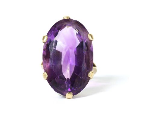 A gold single stone amethyst ring, with an oval mixed cut amethyst, approximately 27 x 16mm, claw set to split shoulders and 