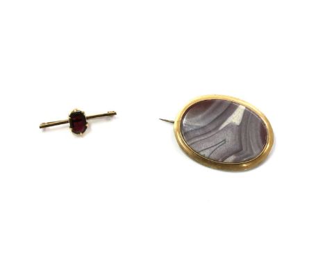 A gold single stone garnet brooch, with an octagonal step-cut garnet, claw set, to a square section bar, with pin and 'C' cat