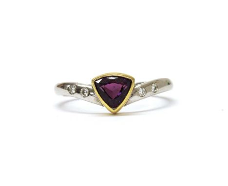 An 18ct gold purple sapphire and diamond ring, with a triangular mixed cut purple sapphire, rub set in yellow gold, to white 