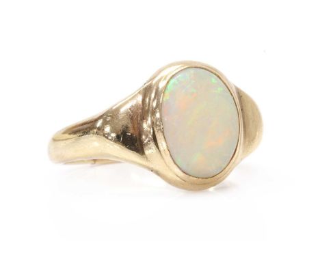 A gold single stone opal ring, with an oval cabochon opal, rub set, to wing shoulders and a 'D' section shank, split at base,