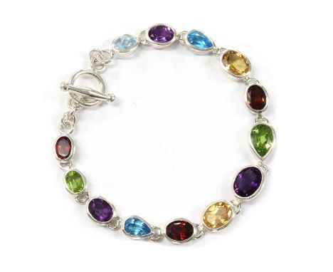 A sterling silver assorted gemstone bracelet, a graduated row of oval and pear shaped mixed cut garnet, citrine, peridot, blu