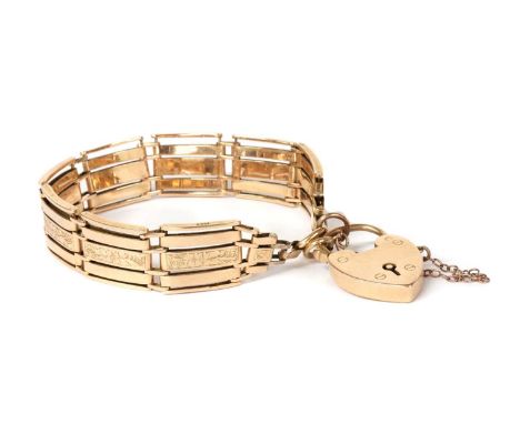 A gold five row gate bracelet, with hand engraved patterning to the central links, and a heart shaped padlock clasp, tested a