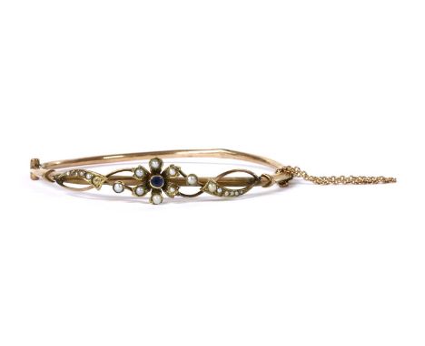 An Edwardian gold sapphire and split pearl bangle, a circular mixed cut sapphire, rub set, to surround of split pearls grain 