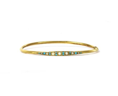 An Edwardian gold split pearl and turquoise oval bangle, the top half with a row of graduated split pearls alternating with t