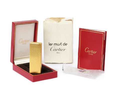 A cased Must de Cartier gold plated gas lighter, reference no. CA040310, of rectangular form with one canted corner, and with