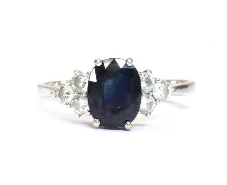 A white gold sapphire and diamond ring, an oval mixed cut sapphire, approximately 8 x 6mm, with a trefoil of brilliant cut di