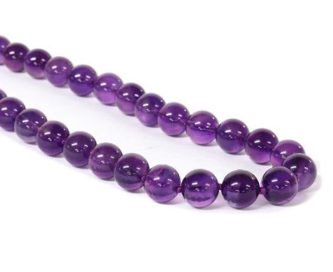 A single row uniform amethyst bead necklace, the amethyst beads, approximately 10mm, strung knotted to a side lever clasp, 56