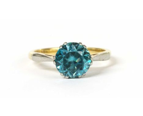 A gold single stone blue zircon ring, a circular mixed cut blue zircon, approximately 8mm, claw set to a scroll collet, with 