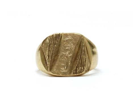 A 9ct gold engraved signet ring, the cushion shaped head with engraved initials and bark effect, London 1977, 6.27g.Finger si