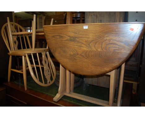 An Ercol light elm dropleaf kitchen table, having gateleg action; together with a pair of Ercol light elm kitchen chairs (3)