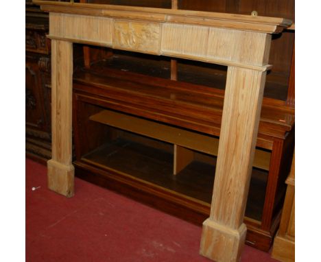 A circa 1900 pine fire surround, having central carved figural panel, w.135cm 