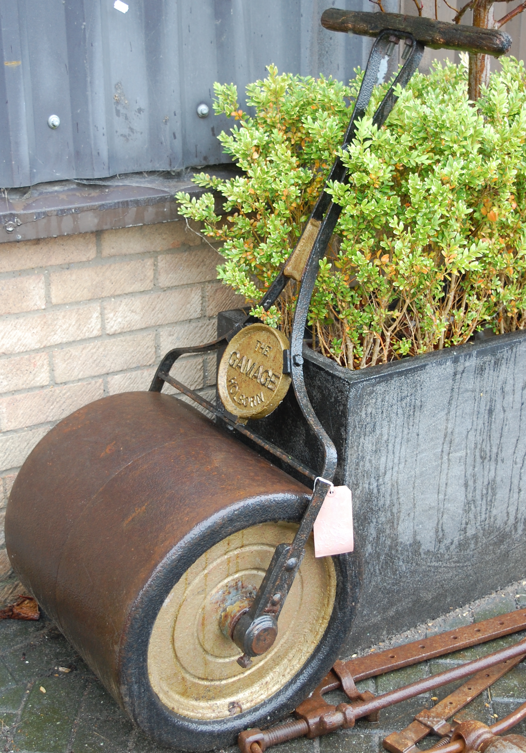 An early 20th century cast iron garden roller by the Gamage, Holborn