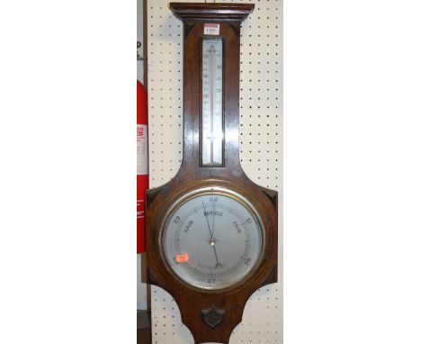 A 1930s moulded oak aneroid two dial wheel barometer 