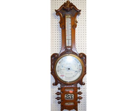 A late Victorian carved oak two dial aneroid barometer 