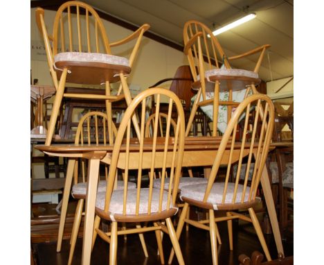 An Ercol light elm dining suite, comprising extending dining table with pull-out action and twin hinge drop-in leaf, and a se