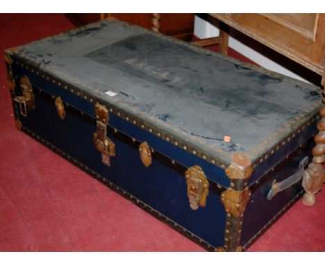 A studded and metal bound hinge-top travelling trunk, having end carry handles, w.102cm 